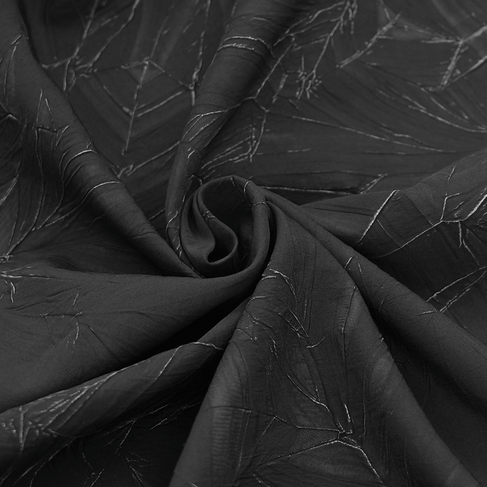 Close-up of luxurious black fabric with intricate patterns, perfect for gothic or punk fashion designs.