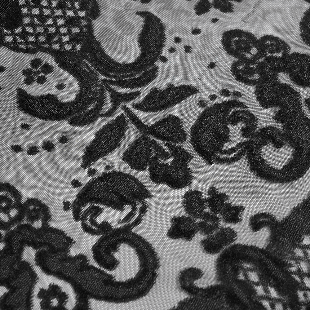 Intricate black lace fabric overlay with decorative patterns enhancing gothic style maxi skirt.