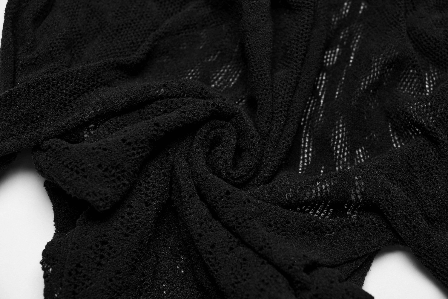 Close-up of black knitted mesh fabric showing intricate patterns and textures, perfect for Gothic fashion.