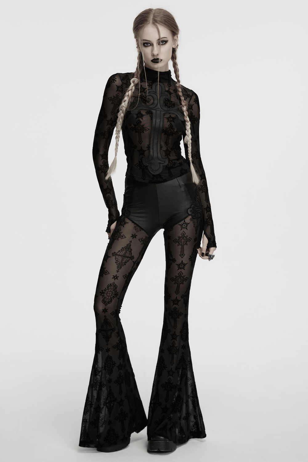 Gothic black mesh long-sleeved top with cross embroidery, styled with bell-bottom pants for a retro look.
