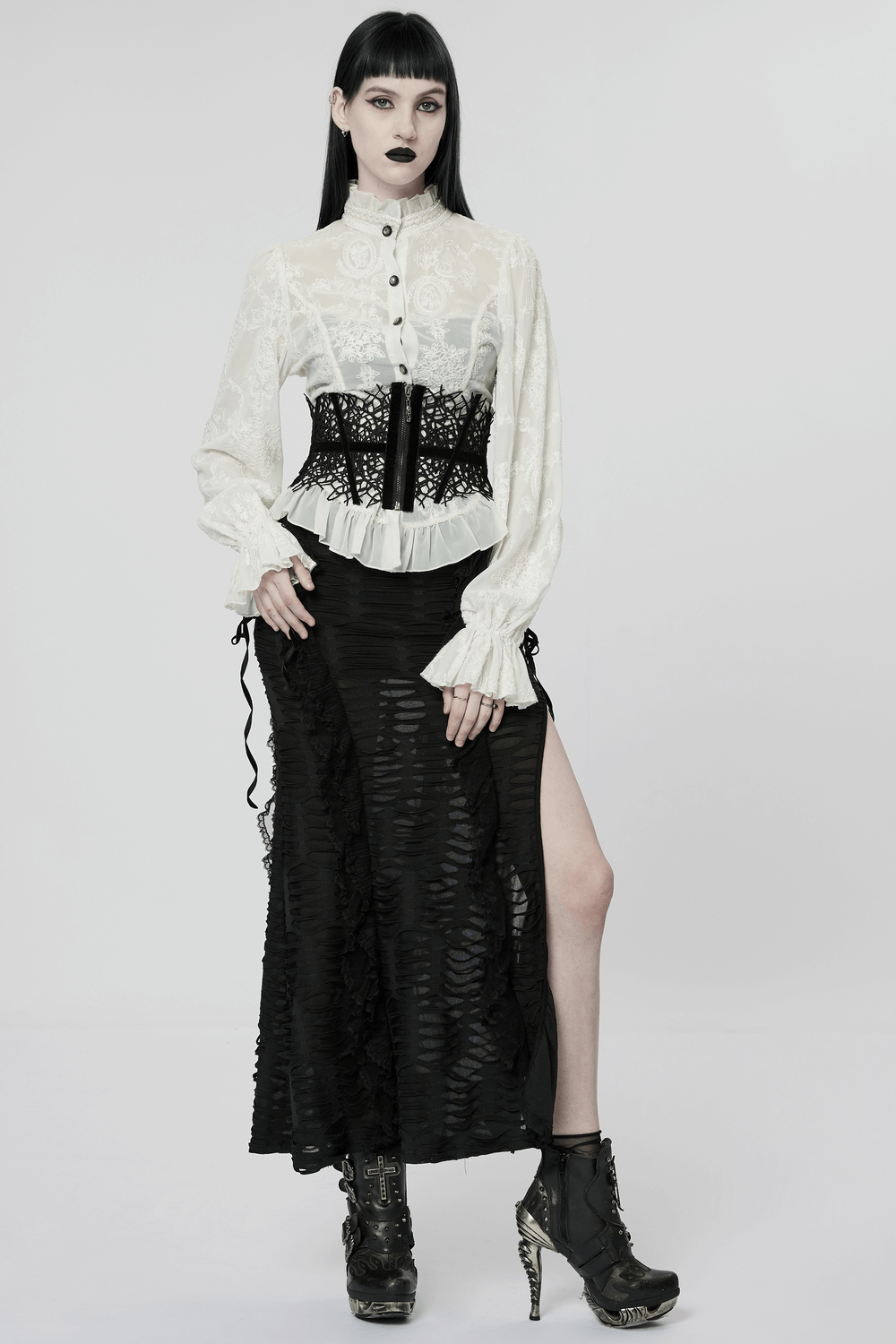 Model wearing a gothic black net corset belt over a white blouse and long black skirt, showcasing a dark fashion style.