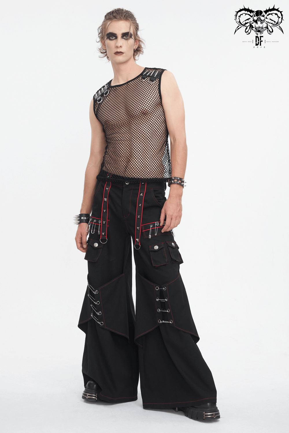 Gothic black pants with red stitch and metal accents, styled with a mesh top for an edgy, fashion-forward look.