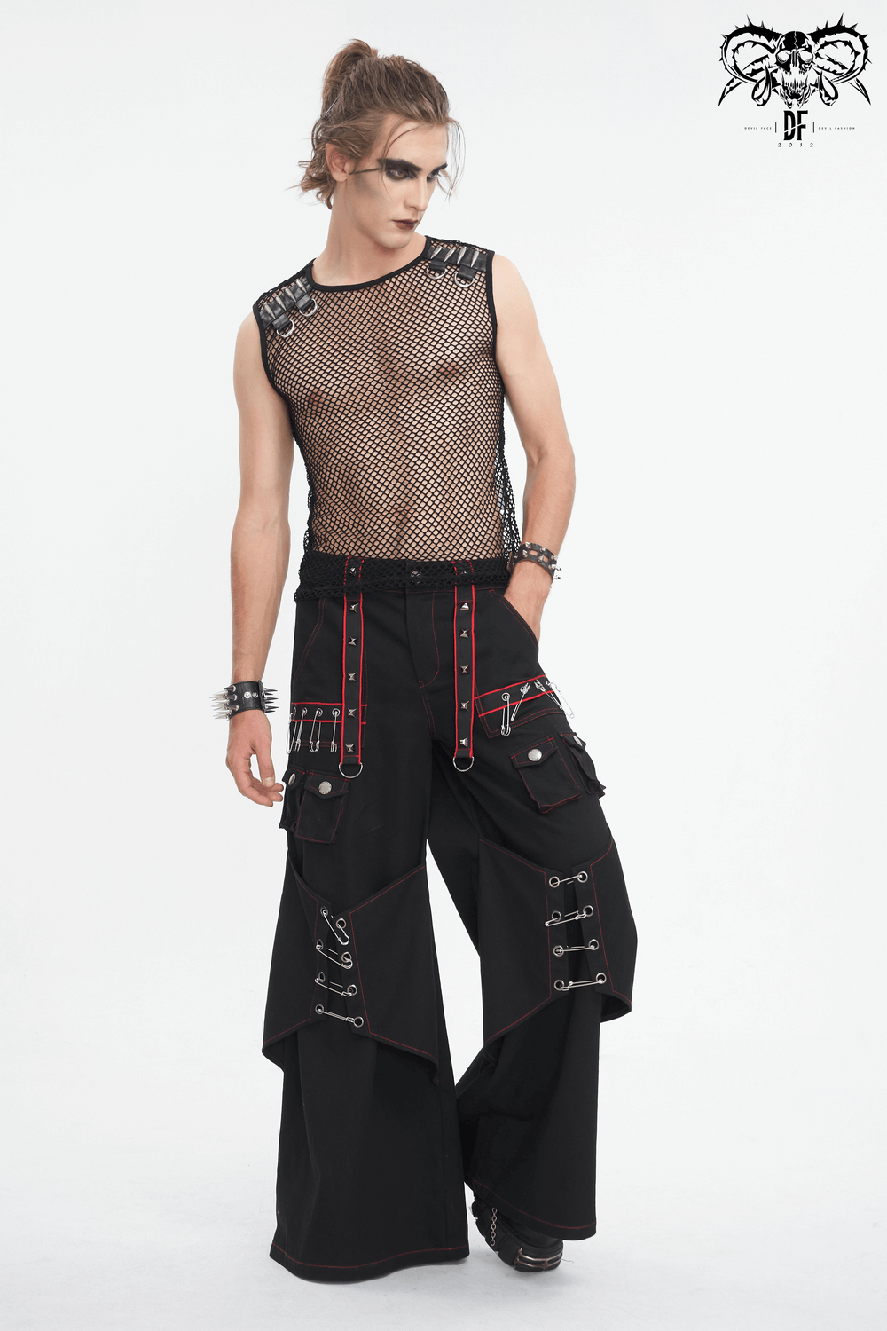 Gothic black pants with red stitching and metal accents, styled with a sheer mesh top, perfect for edgy fashion lovers.