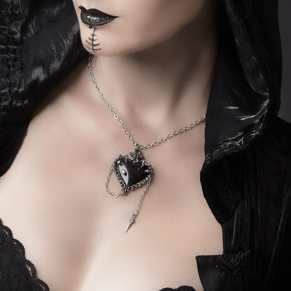 Gothic black pewter witches heart pendant with chain and nail detail, worn by a model in dark attire.