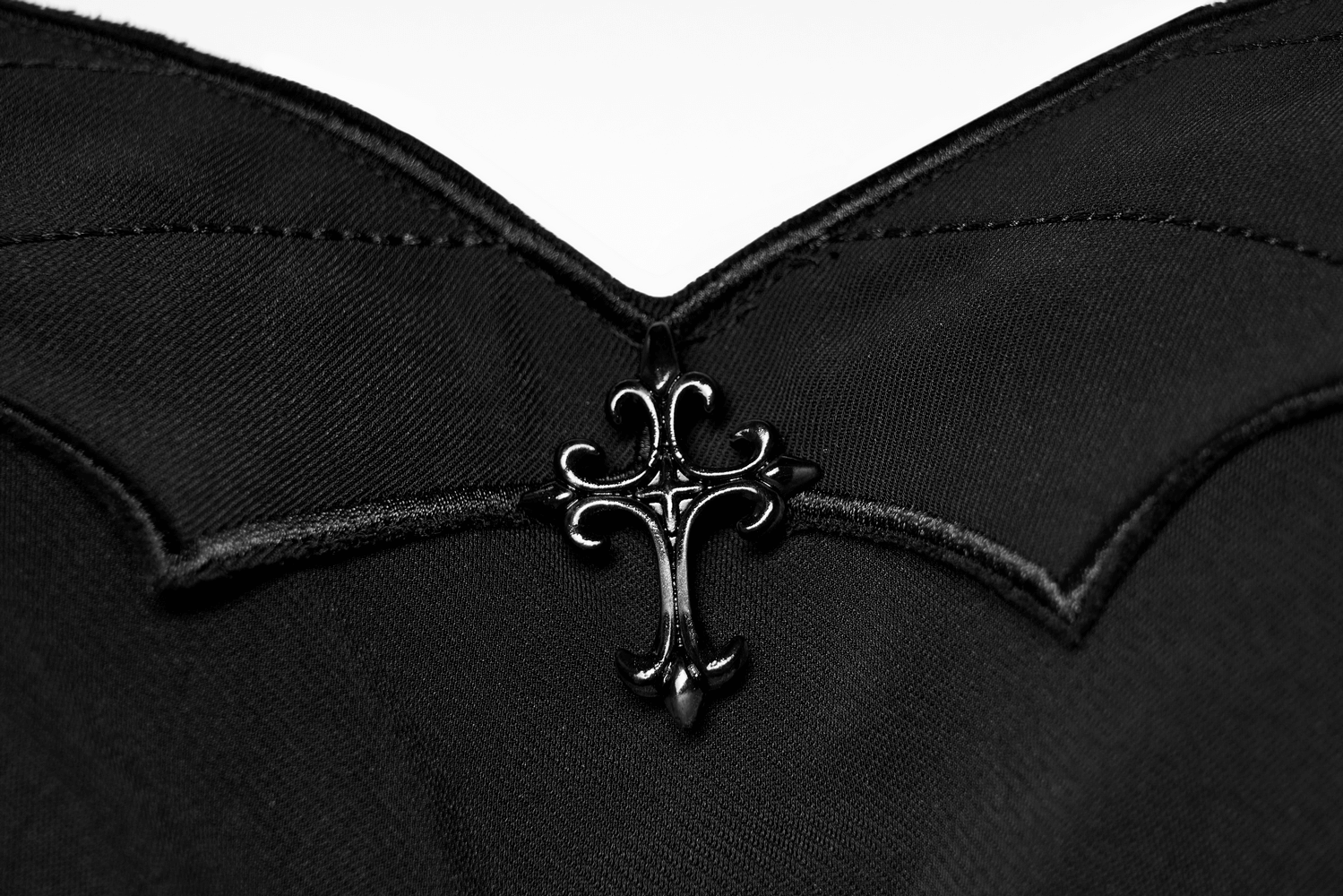 Close-up of the Gothic Black Scalloped Skater Dress featuring a decorative black bat cross on the neckline.