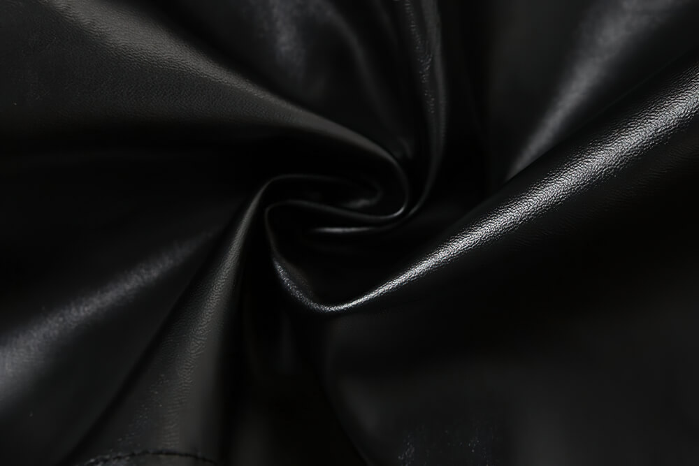 Close-up of luxurious black fabric showcasing a smooth, glossy texture perfect for gothic fashion.