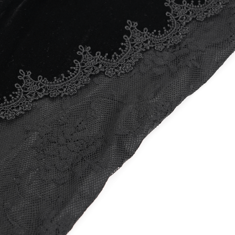 Close-up of gothic black velvet and lace detailing with intricate baroque embroidery on flared pants.
