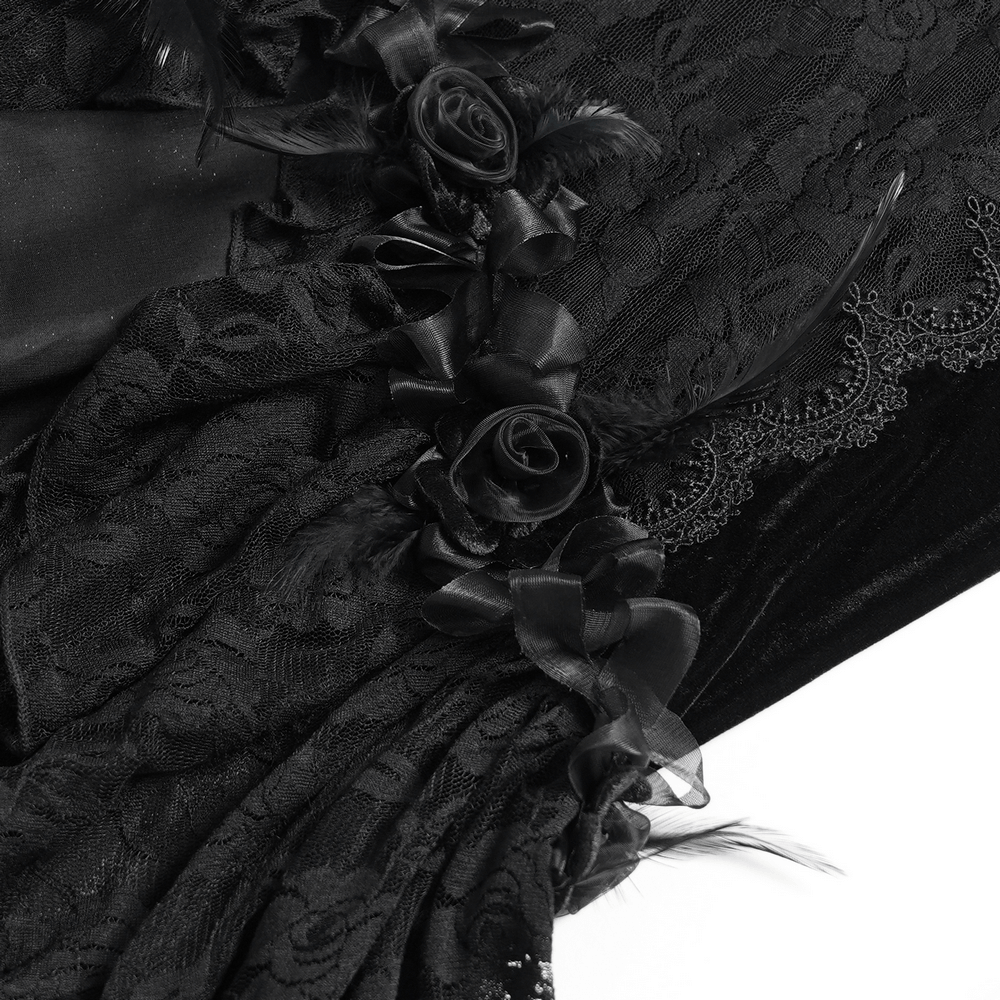 Close-up of gothic black velvet dress with lace overlay, satin rose trim, and feather details.