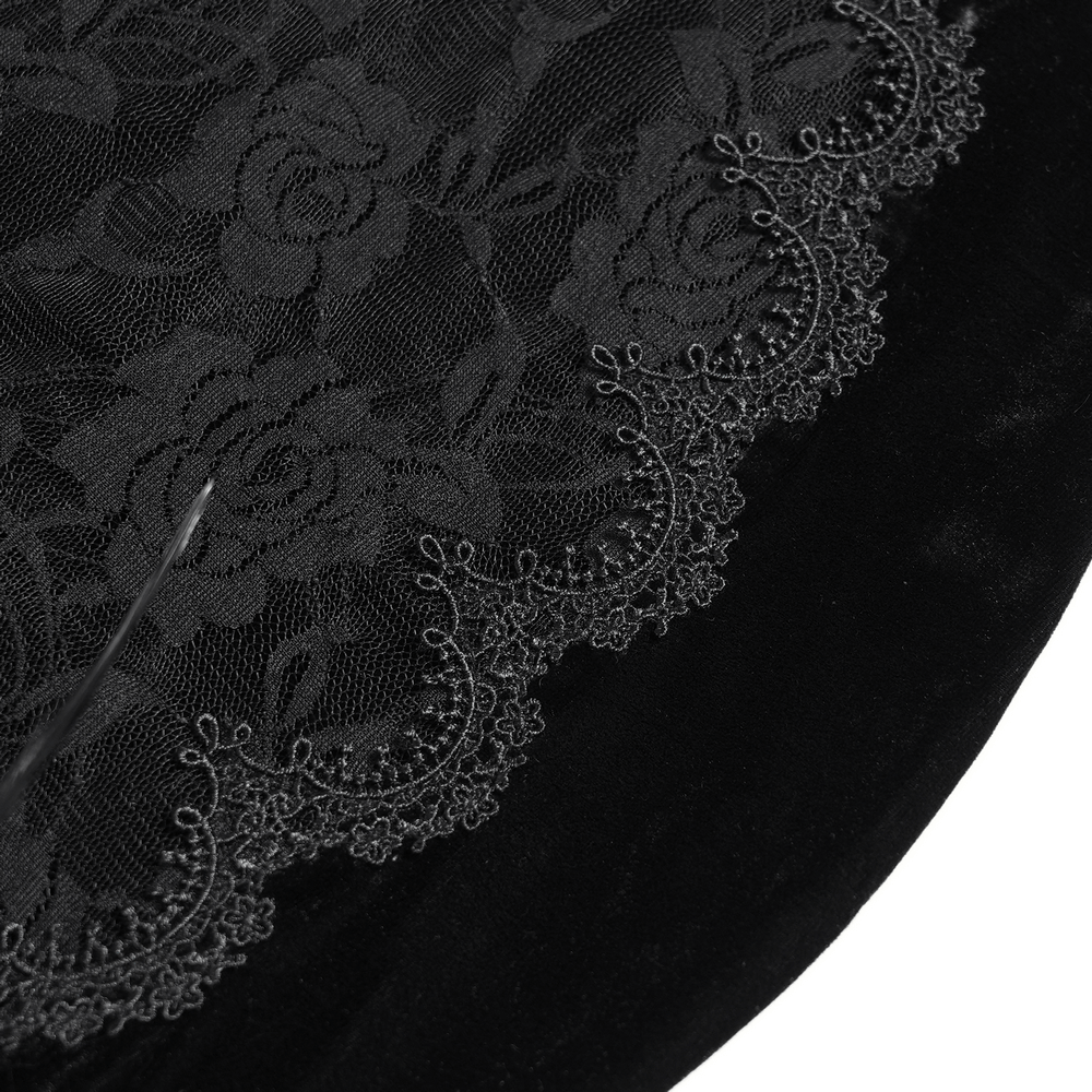 Close-up of floral lace and velvet detailing on a gothic black evening dress accentuating dark elegance.