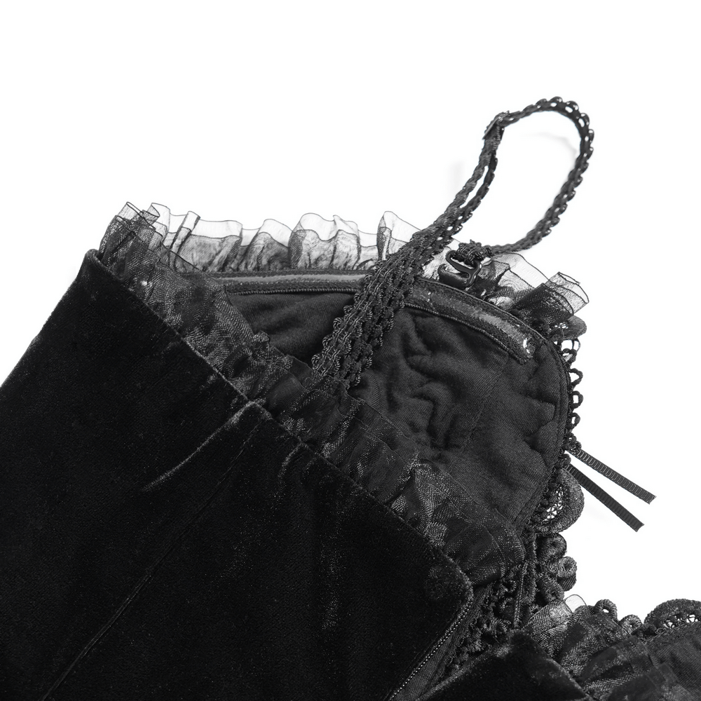 Detail of black velvet high-low evening dress with lace trim and spaghetti straps, showcasing elegant ruffles.