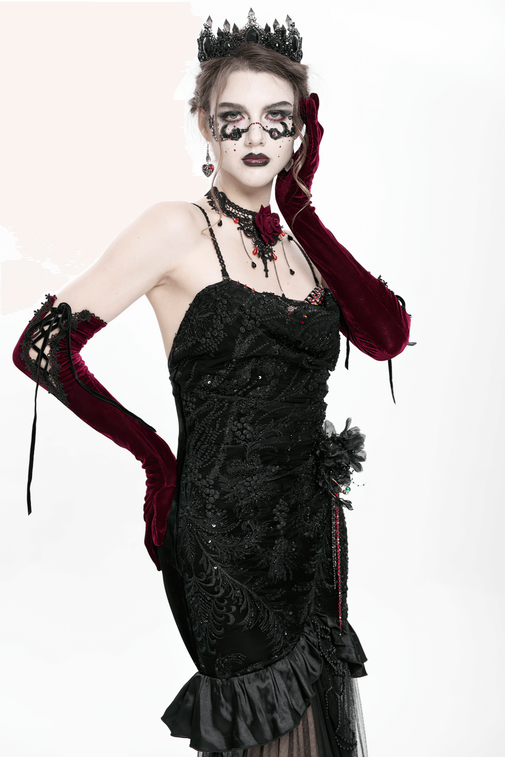 Gothic black velvet evening gown with sheer mesh, intricate embroidery, and dramatic accessories.