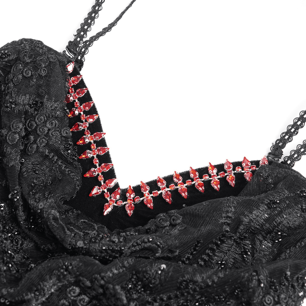 Close-up of beaded neckline detail on gothic black velvet dress, featuring red gems and intricate embroidery.