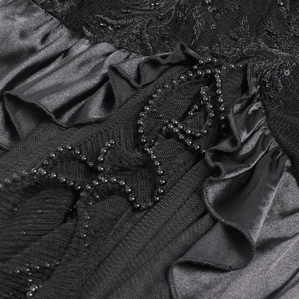 Close-up of Gothic black velvet dress details with intricate beadwork and delicate ruffles.