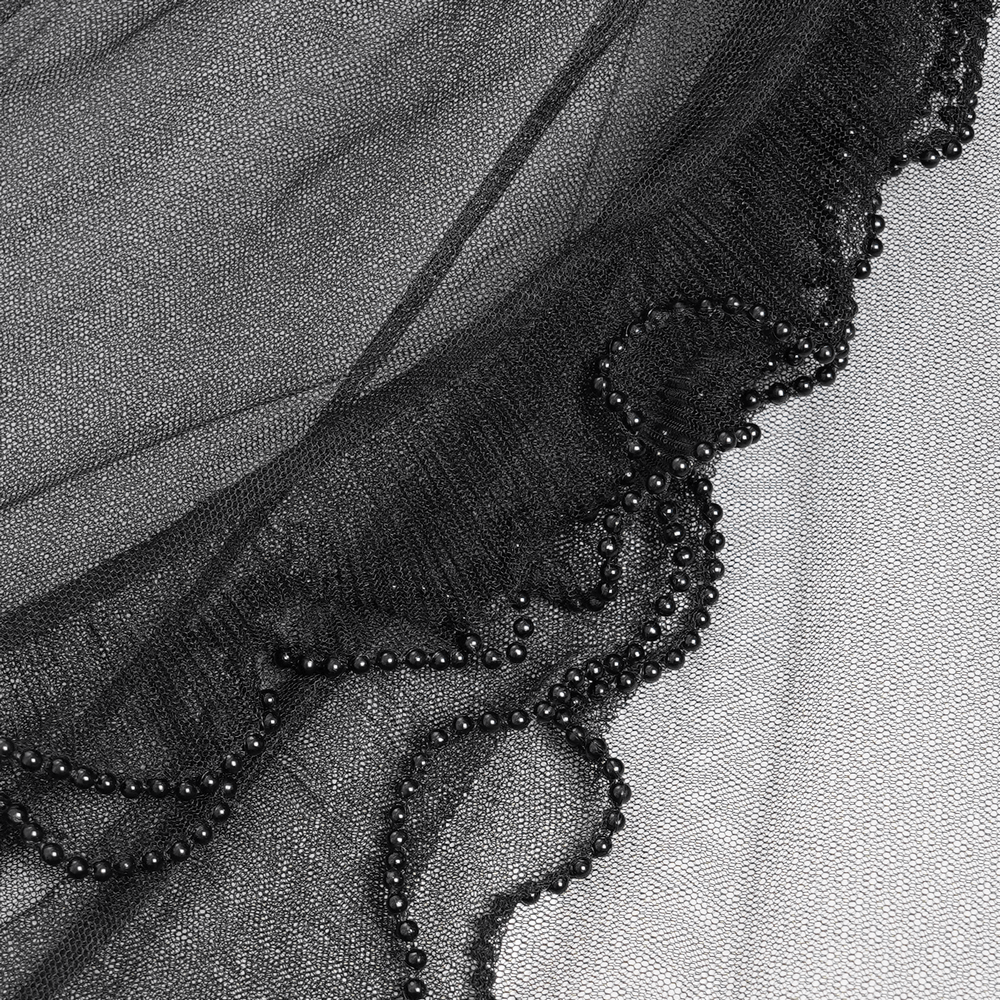 Close-up of black sheer mesh fabric with delicate ruffles and beaded edging, perfect for gothic fashion.