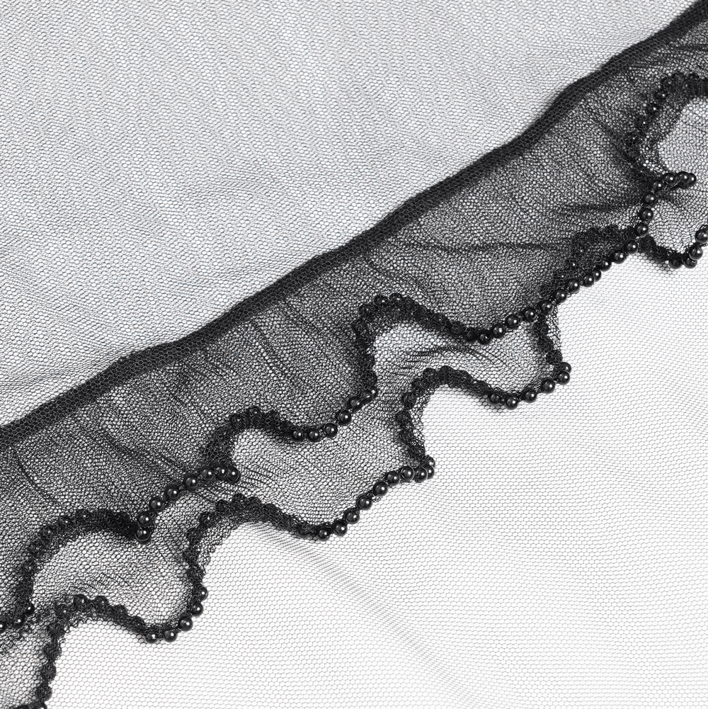 Close-up of black sheer mesh fabric with delicate ruffled edges and beaded detailing, ideal for gothic dress embellishments.