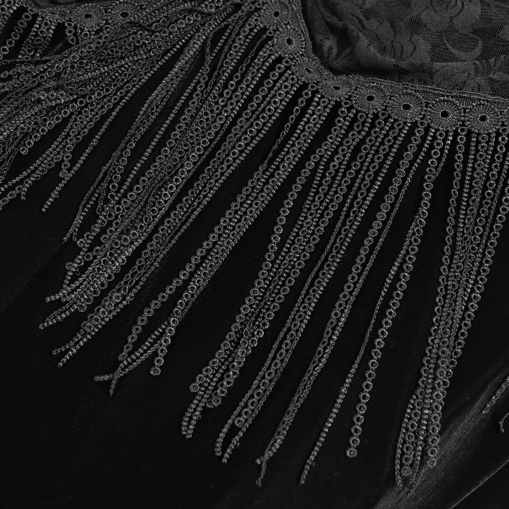 Close-up of gothic black velvet dress with intricate lace and dramatic fringe details for a Victorian-inspired look.