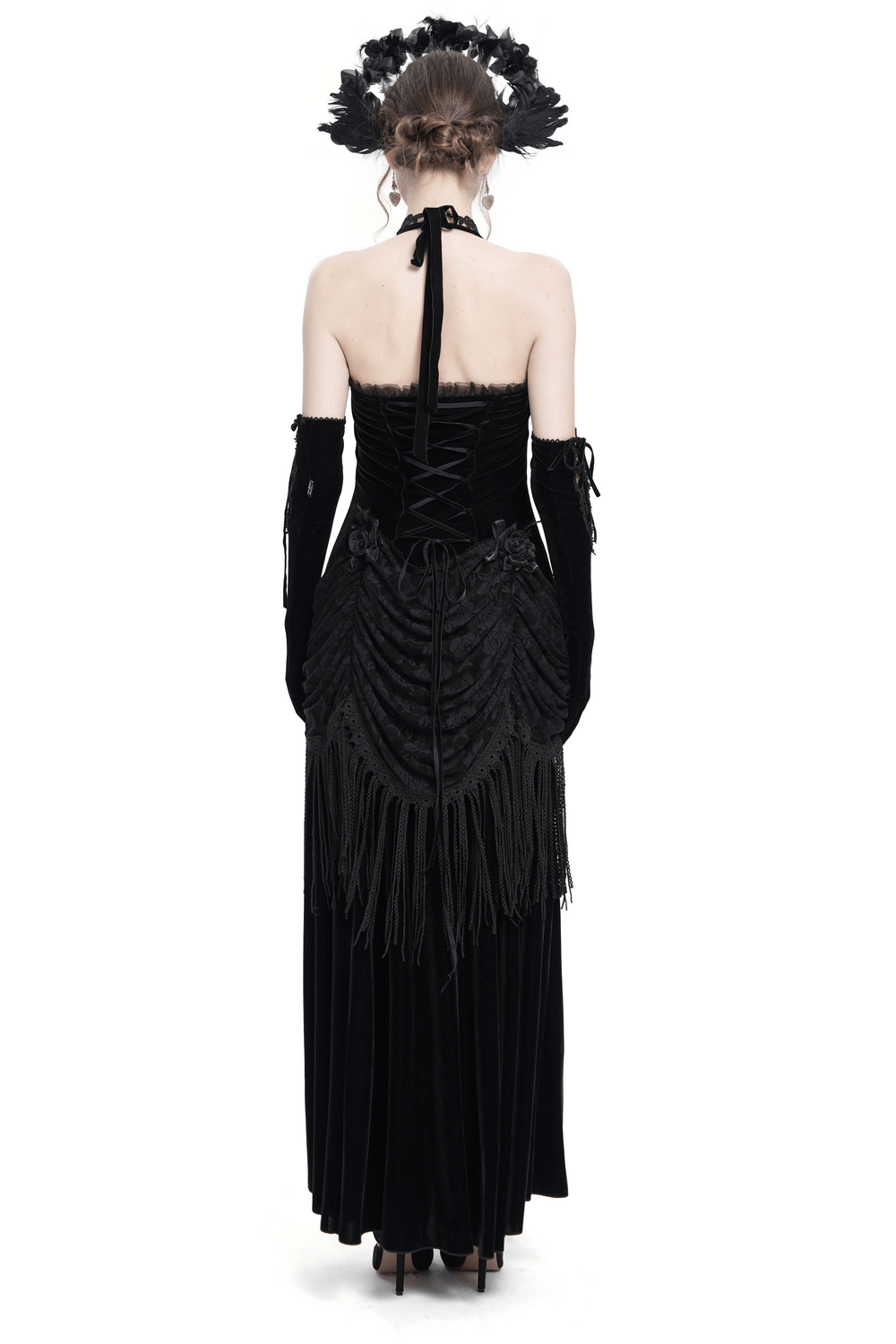 Back view of a gothic black velvet halter dress with lace-up corset and dramatic fringe details.
