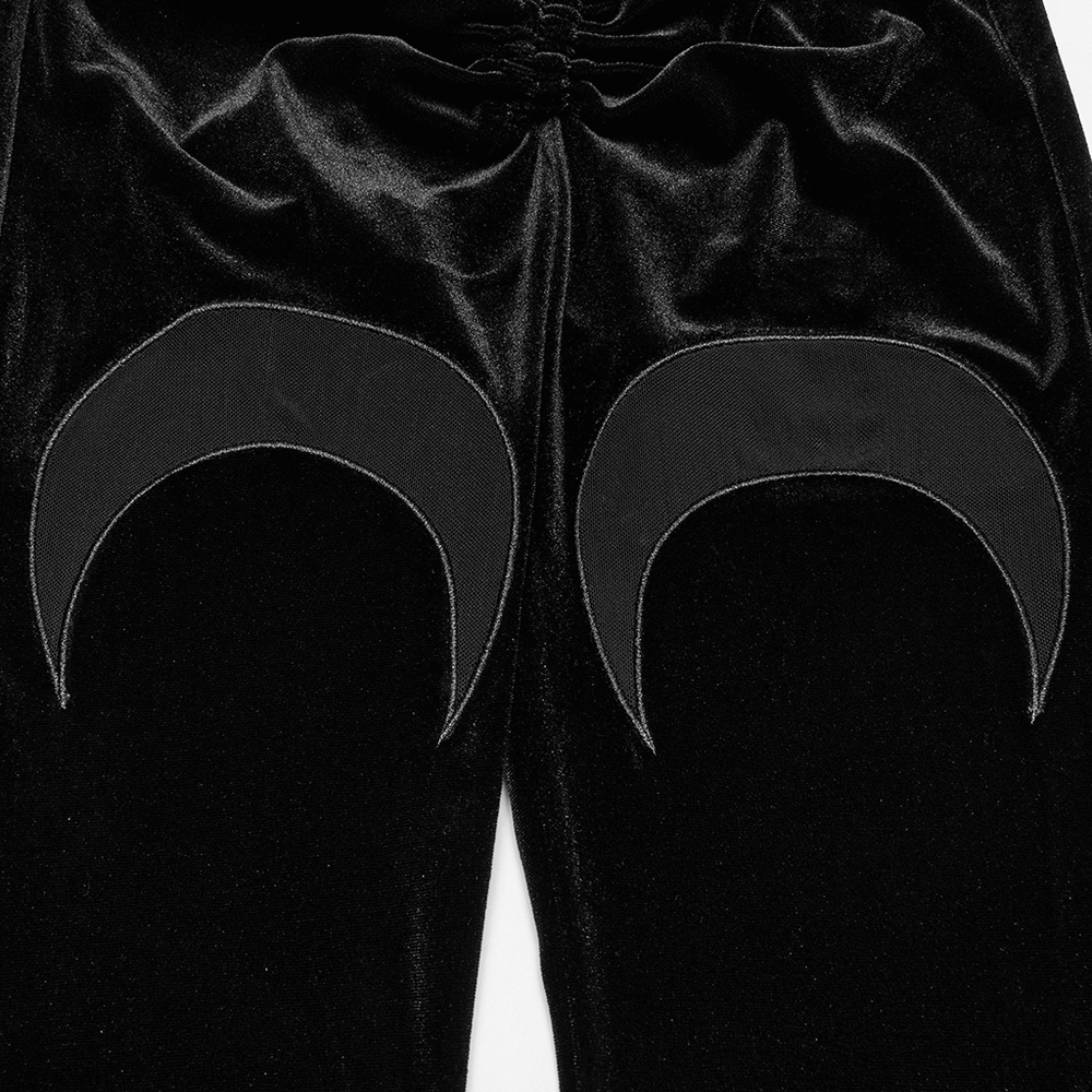 Close-up of black velvet flared pants featuring crescent moon mesh cutouts and ruched detailing on the back.