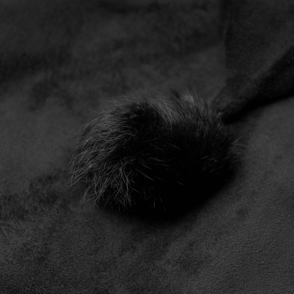 Close-up of the detachable hairball accent on a gothic black velvet hoodie.