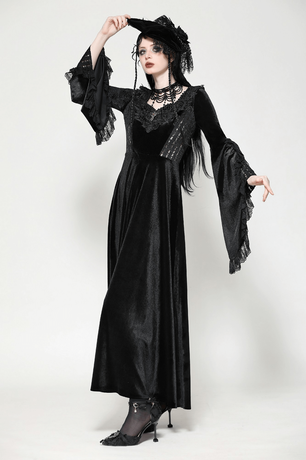 Elegant woman in a Gothic black velvet lace-up Renaissance dress with bell sleeves and lace details. Perfect for formal events.