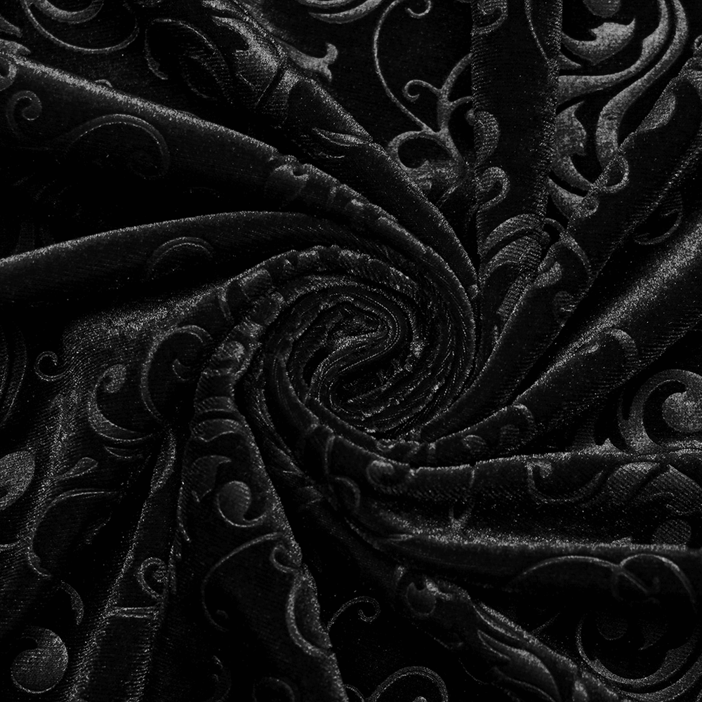 Close-up of elegant embossed black velvet fabric, showcasing intricate swirling patterns and luxurious texture.