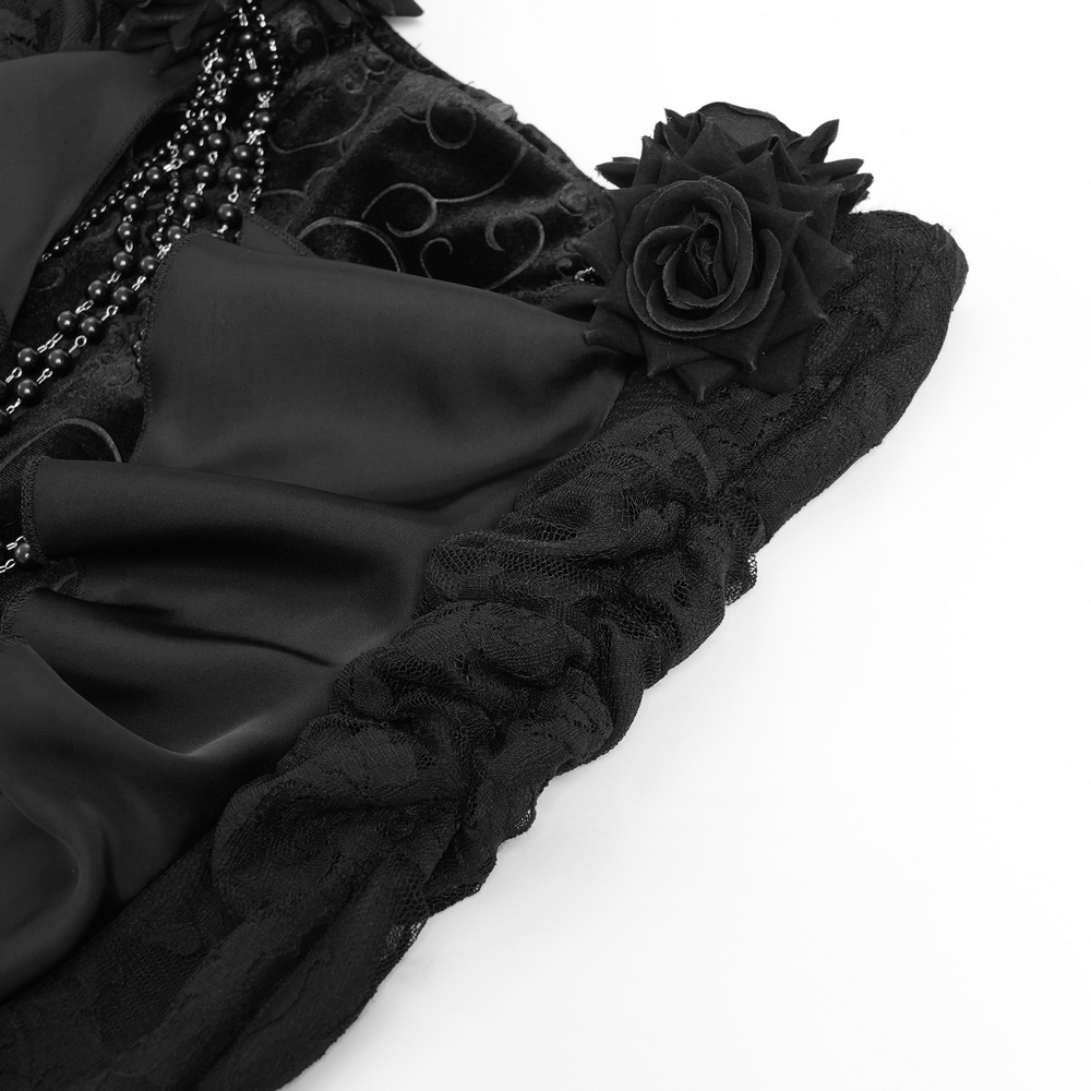Close-up of elegant gothic black velvet skirt showcasing ruffles, lace trim, and black rose accents.