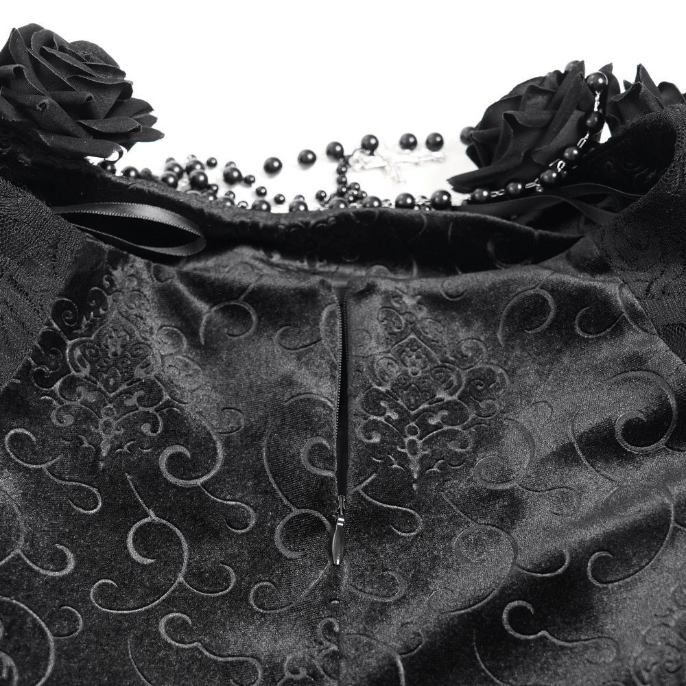 Close-up of elegant black velvet garment featuring floral accents and intricate lace details, perfect for gothic fashion.