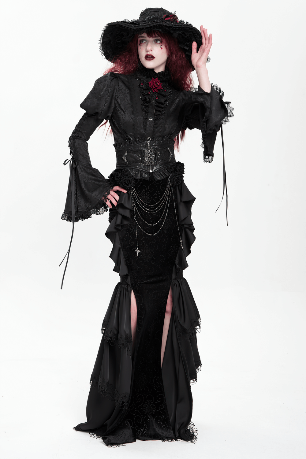 Gothic black velvet maxi skirt with ruffles and chains, paired with an elegant corset and dramatic hat.