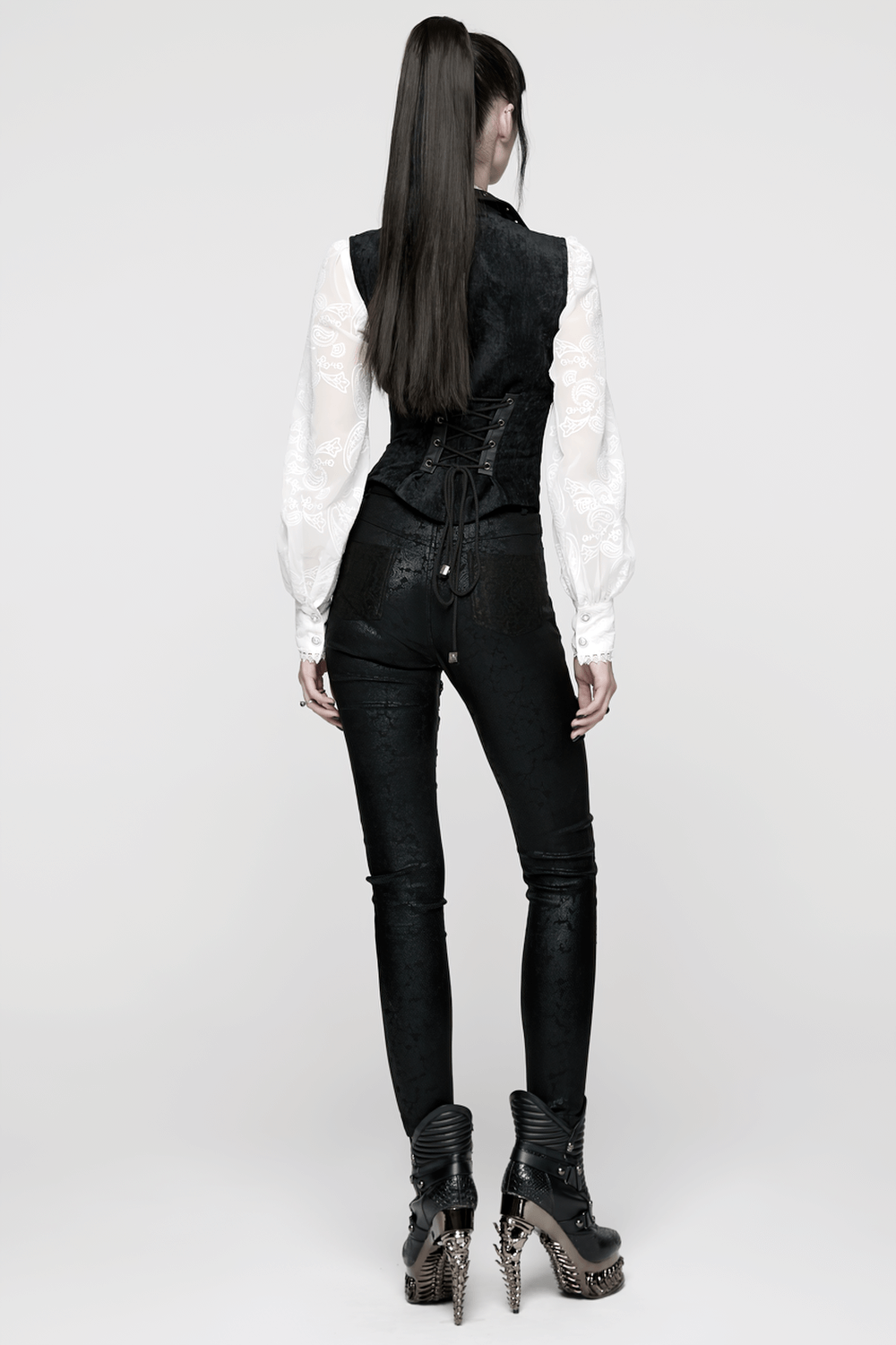 Gothic Black Velvet Punk Vest with Buckle Straps worn with black pants and spiked heels from the back.