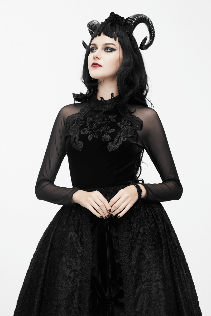 Gothic black velvet top with embroidery and long mesh sleeves, styled with horns and a dramatic skirt.