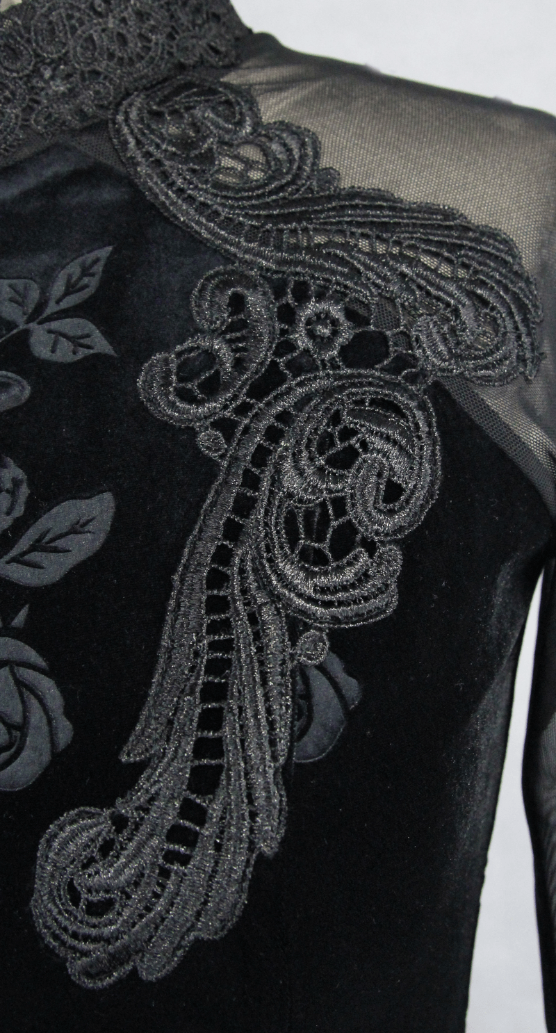 Close-up of gothic black velvet top with intricate embroidery and long mesh sleeves, featuring elegant rose detail.