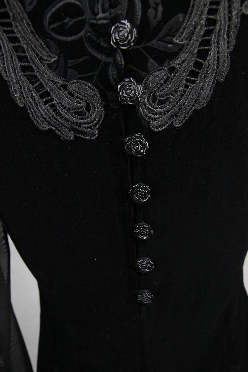 Close-up of gothic black velvet top showing intricate embroidery and rose button details.