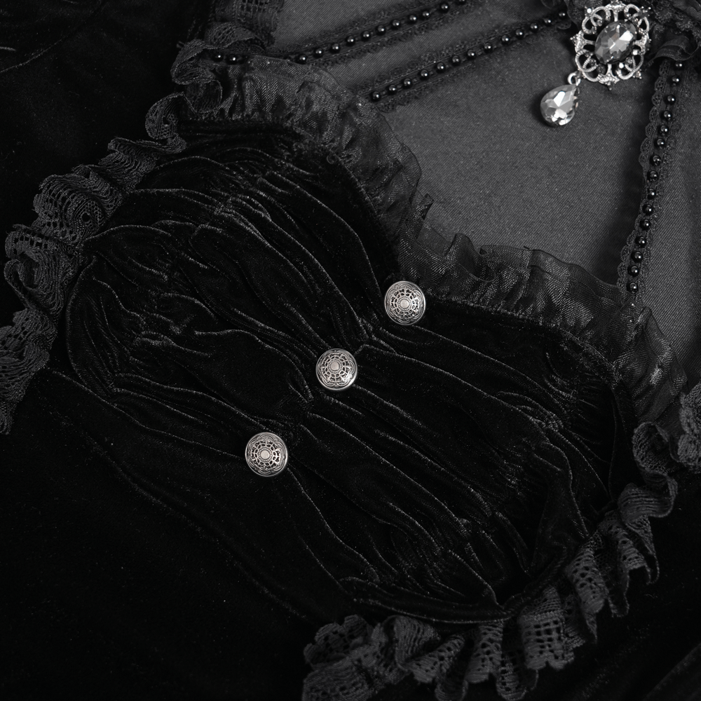 Close-up of gothic black velvet top with lace ruffle trim and ornate buttons, showcasing Victorian-inspired design details.