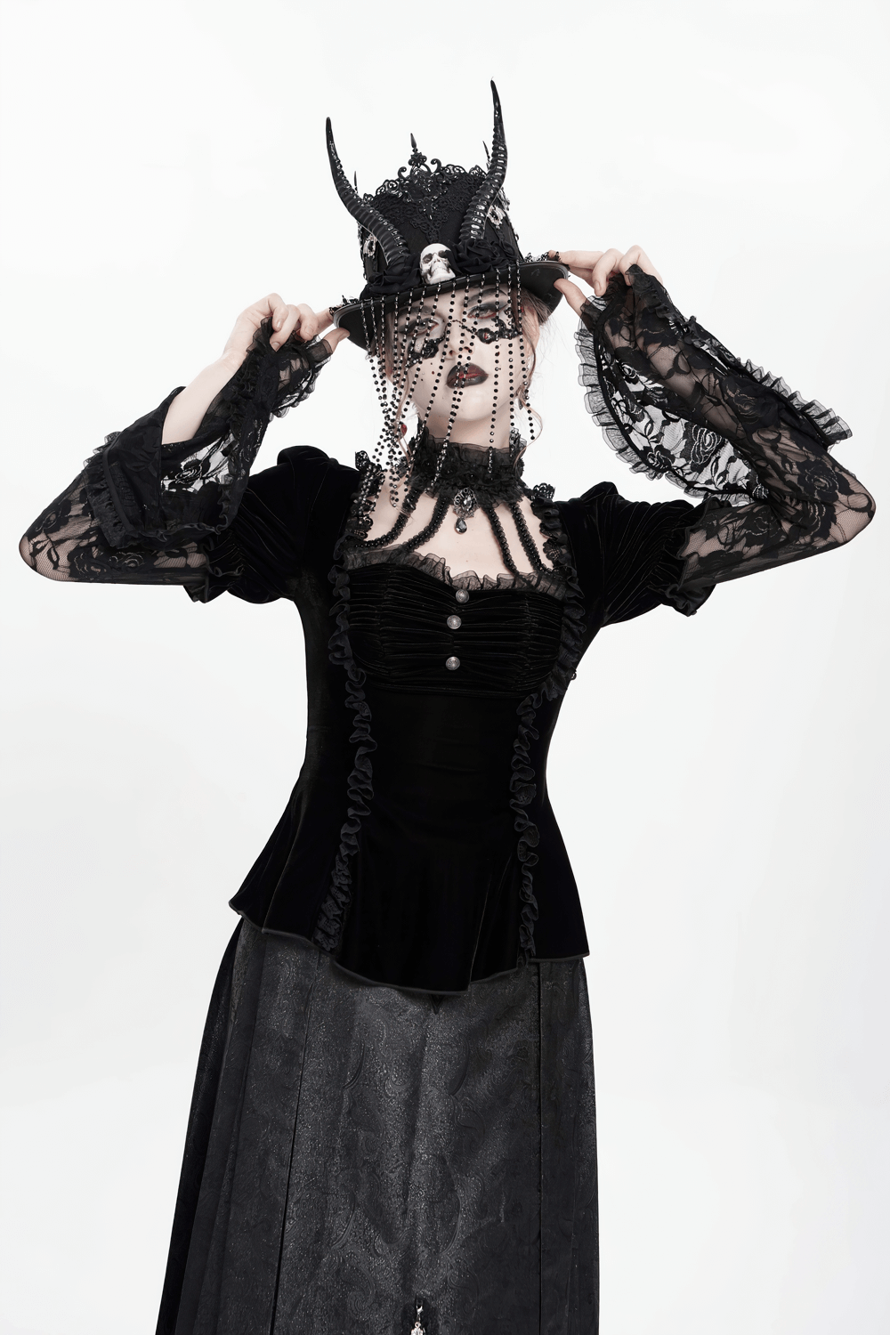 Gothic black velvet top with lace bell sleeves, worn with a dramatic crown and veiled accessory, exuding Victorian elegance.