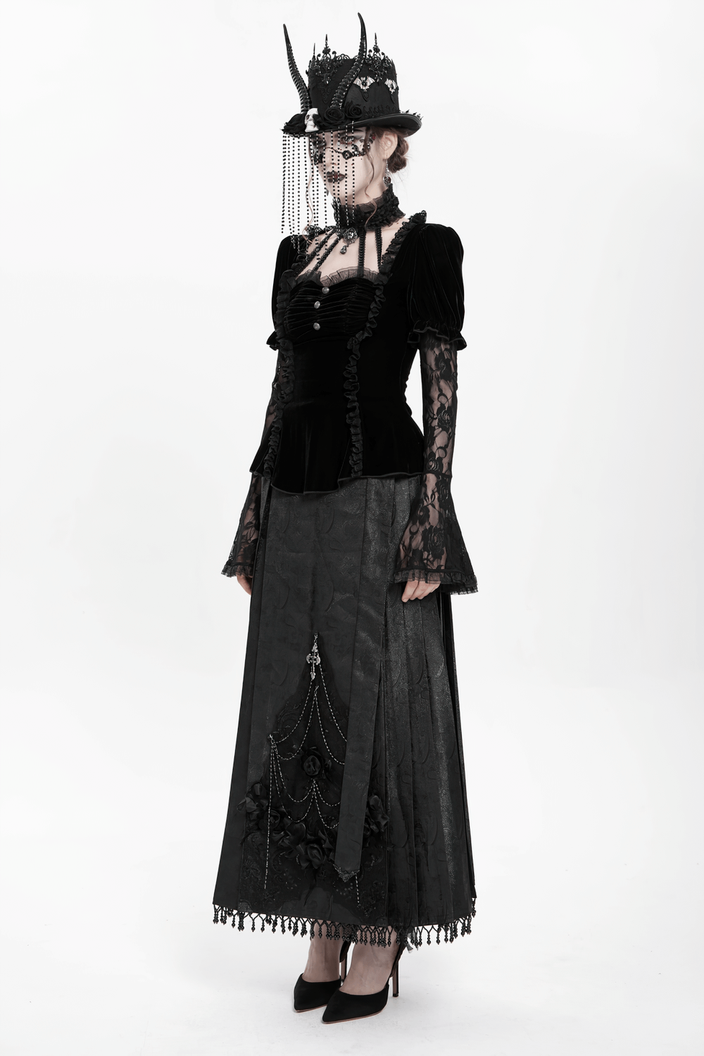Gothic black velvet top with lace bell sleeves and long skirt, embodying Victorian-inspired dark elegance.