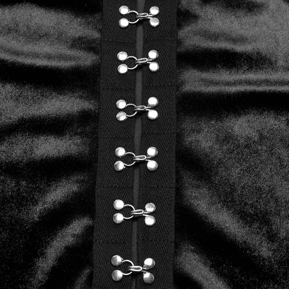 Close-up of metal buckles on a gothic black velvet top, highlighting sleek design and bold accessories.