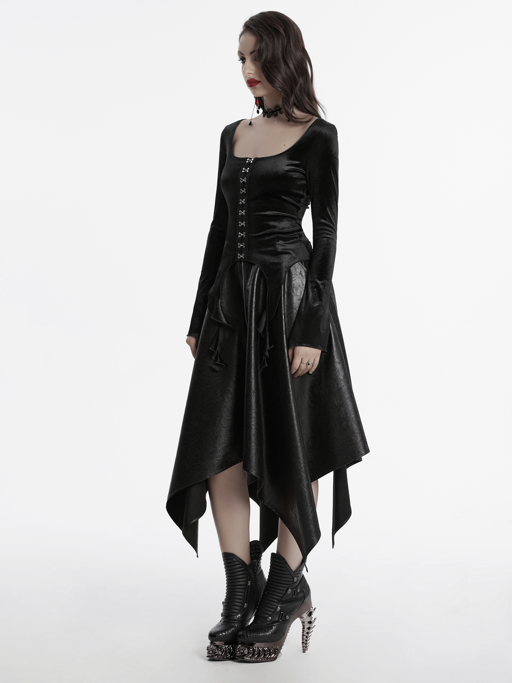 Gothic black velvet top with square collar, metal buckles, and asymmetric hem, paired with edgy boots.