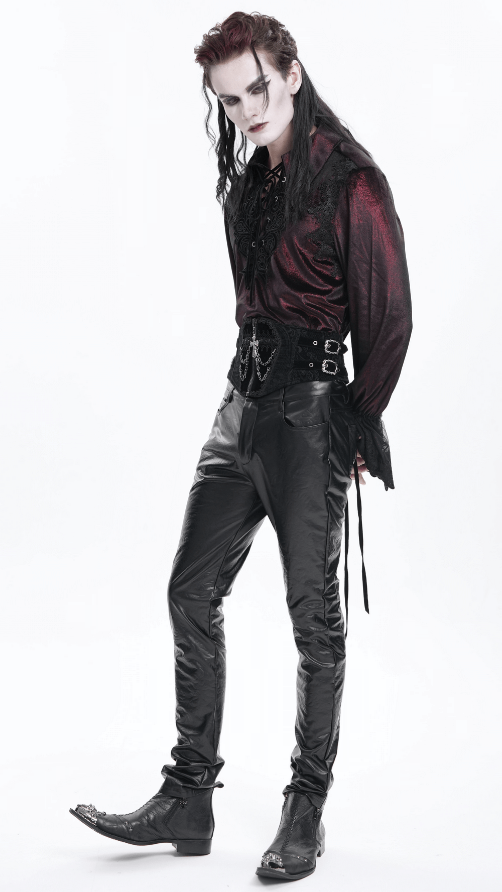 Male model in gothic attire wearing a black waist cincher with chains and a cross, showcasing a dark and edgy style.