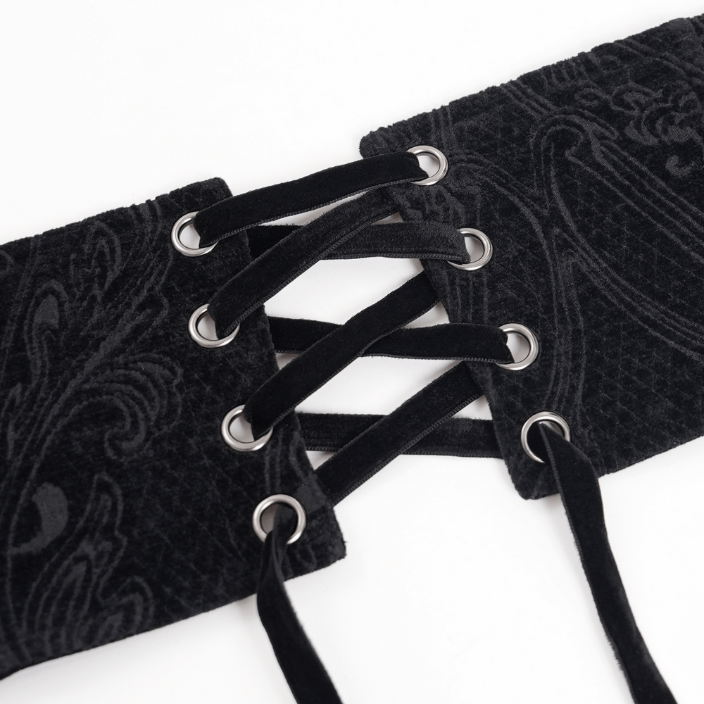 Close-up of a gothic black waist cincher showcasing intricate lace-up detailing and paisley patterns.