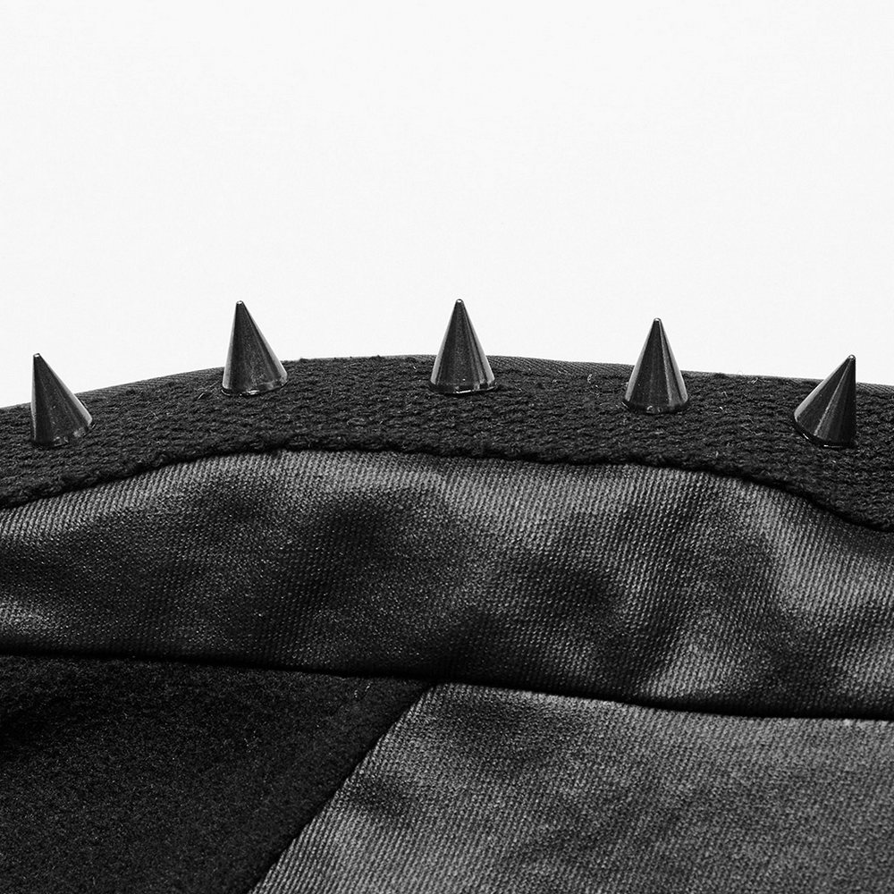 Close-up of spiked accents on a gothic black woolen cape, showcasing edgy detail and punk style.