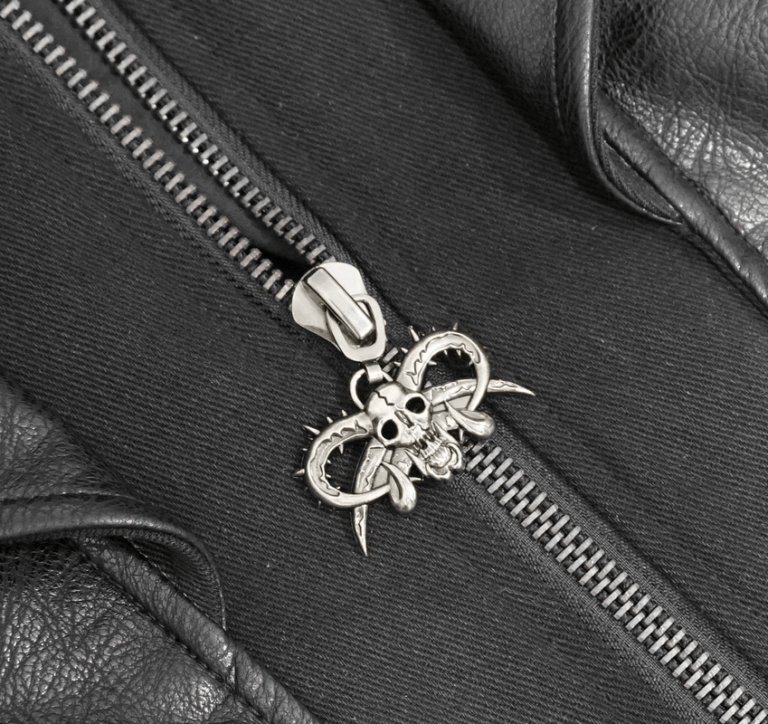Gothic black zipper pull with skull design on leather coat, showcasing unique detailing and style.