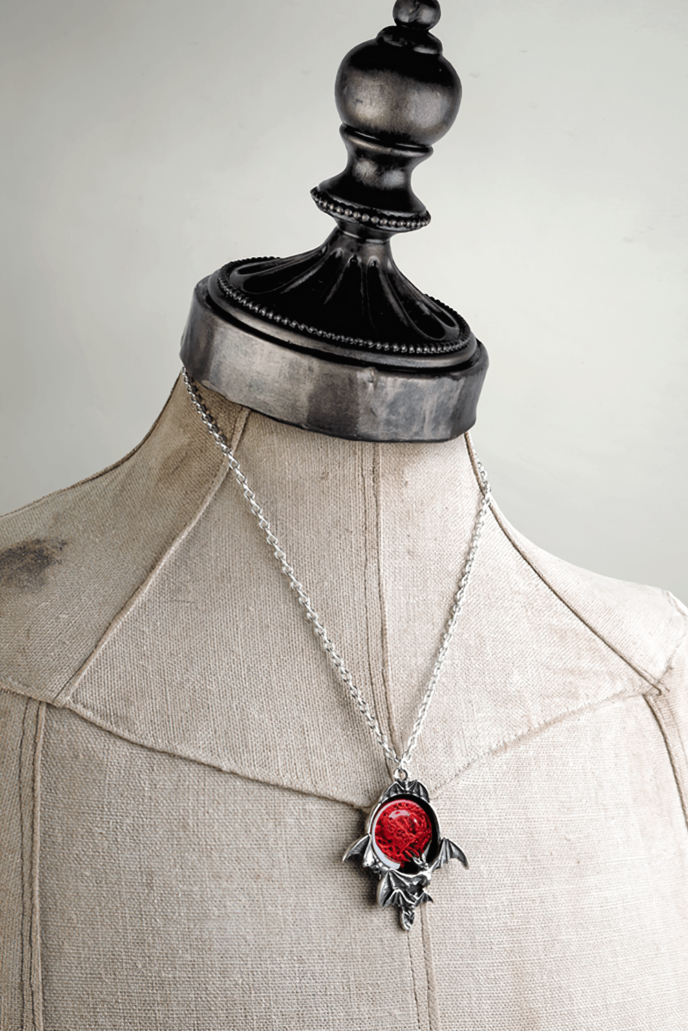 Gothic blood moon pendant with red enamel bats on a mannequin, showcasing dark elegance and vampire charm.
