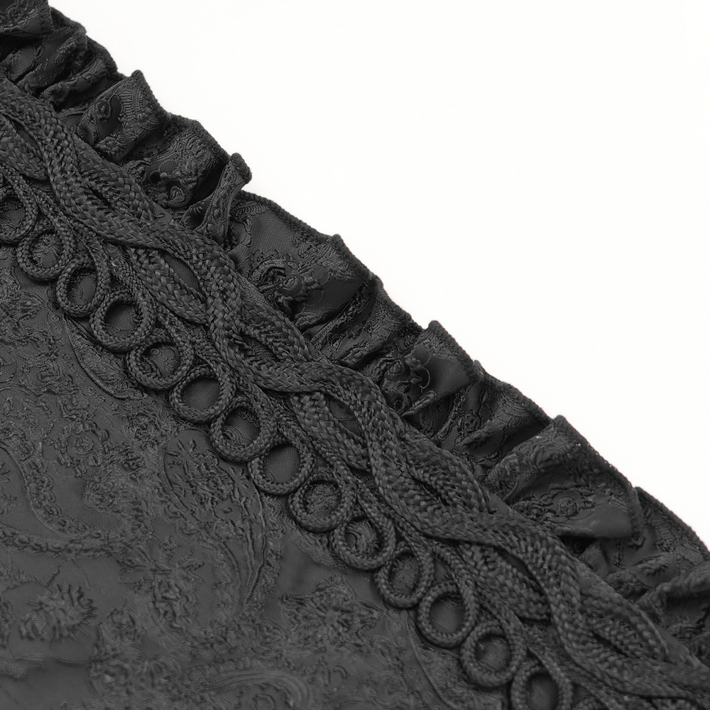 Close-up of intricate lace trim and textured black brocade fabric for a gothic hooded coat.