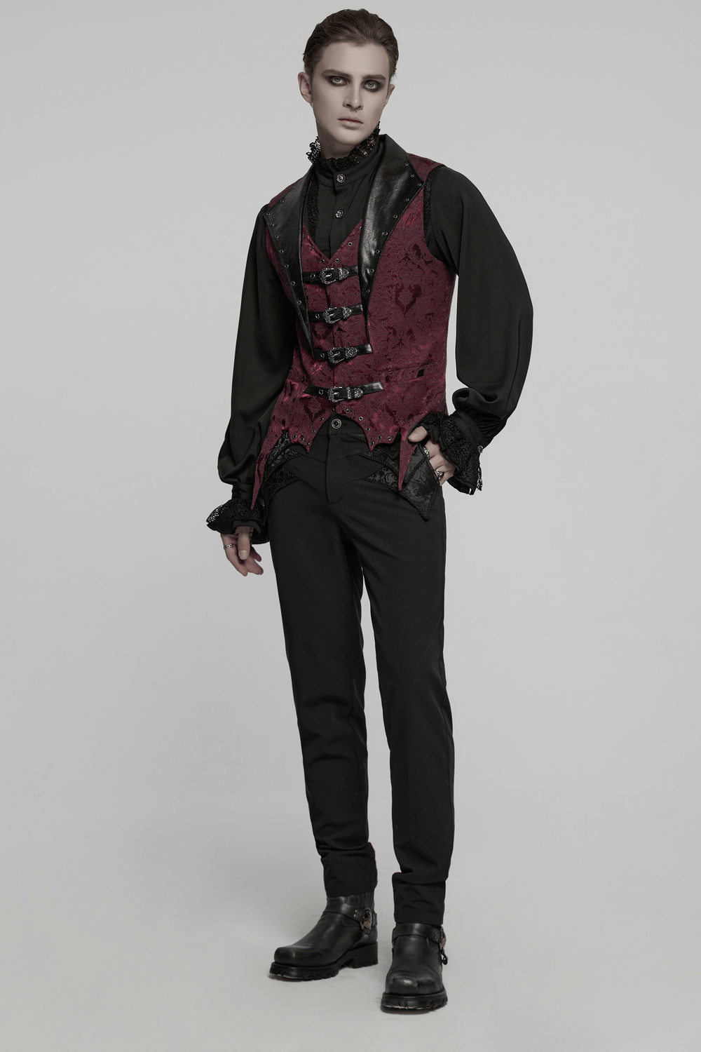 Gothic brocade waistcoat with leather buckles and bat hem, styled with black trousers and shirt for a dramatic look.