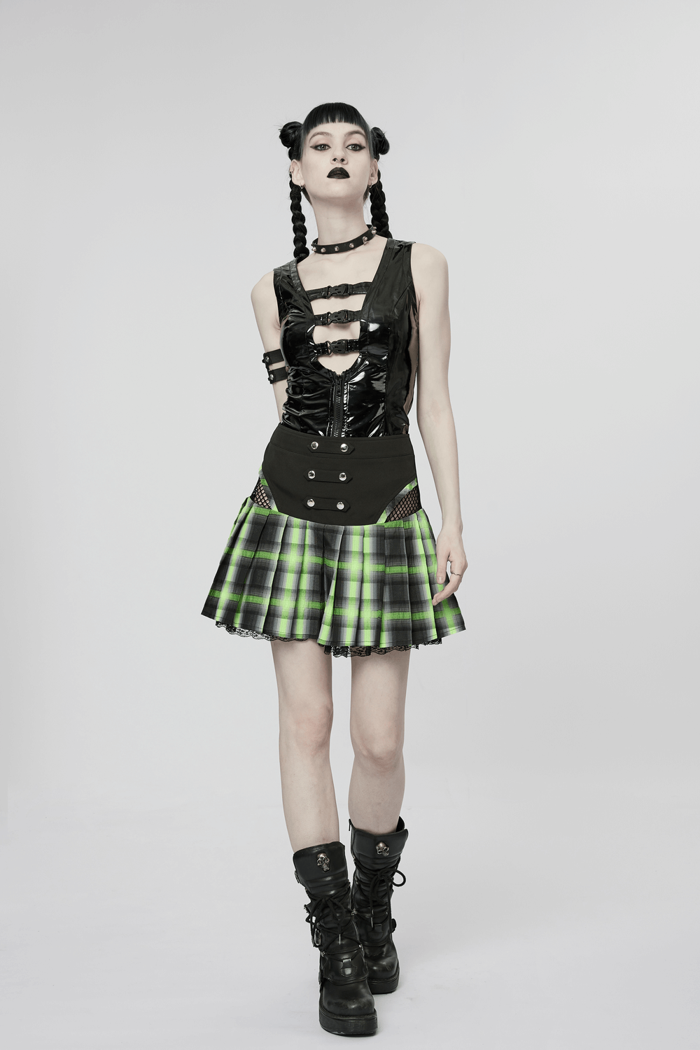 Model showcasing a Gothic Buckle Patent Leather Slim Vest paired with a green plaid skirt and chunky boots.
