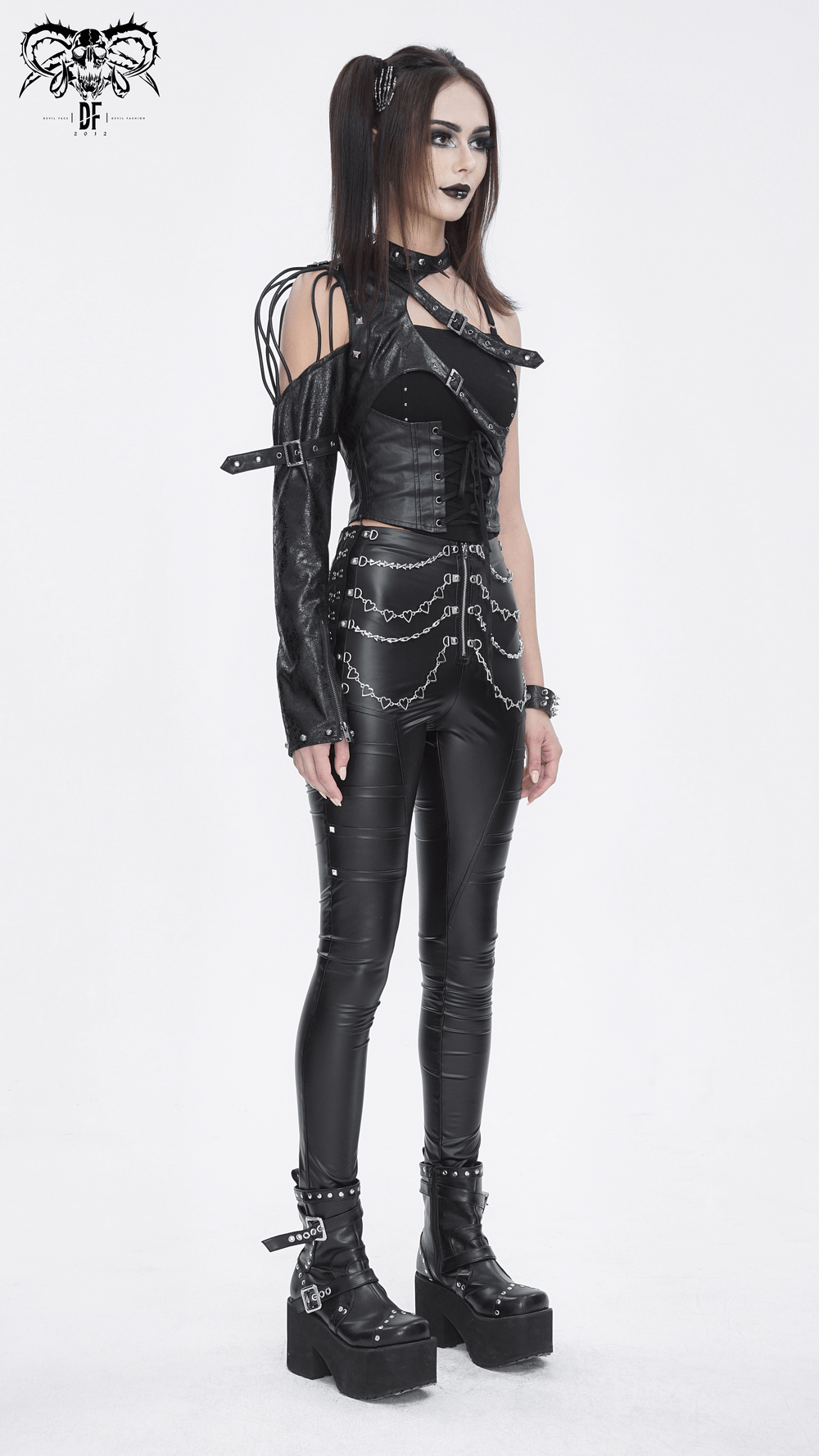 Gothic one-shoulder black harness with chains, paired with sleek black leggings and platform boots for a bold urban look.
