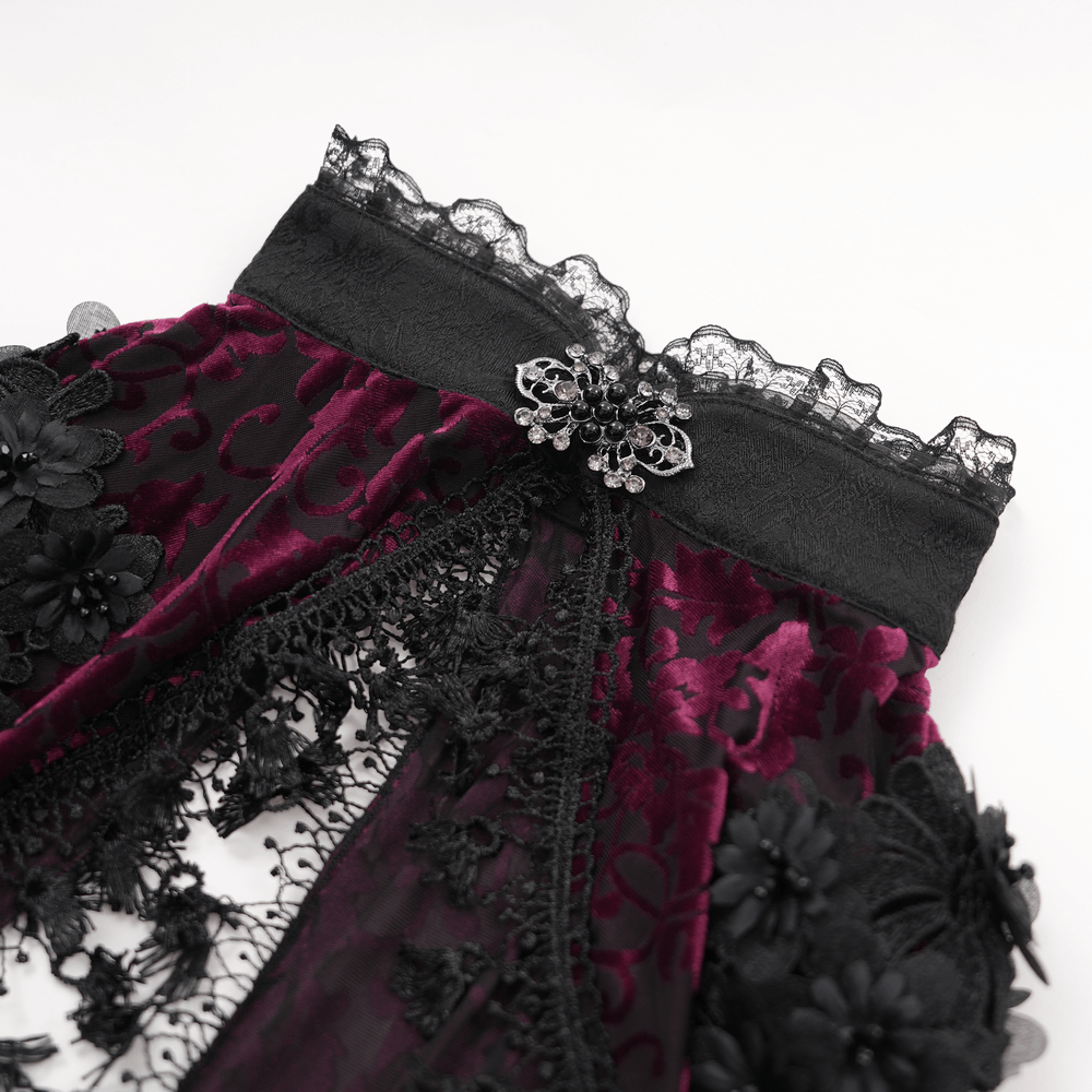 Close-up of a gothic burgundy lace bolero with floral details and a decorative brooch, showcasing its elegant design.