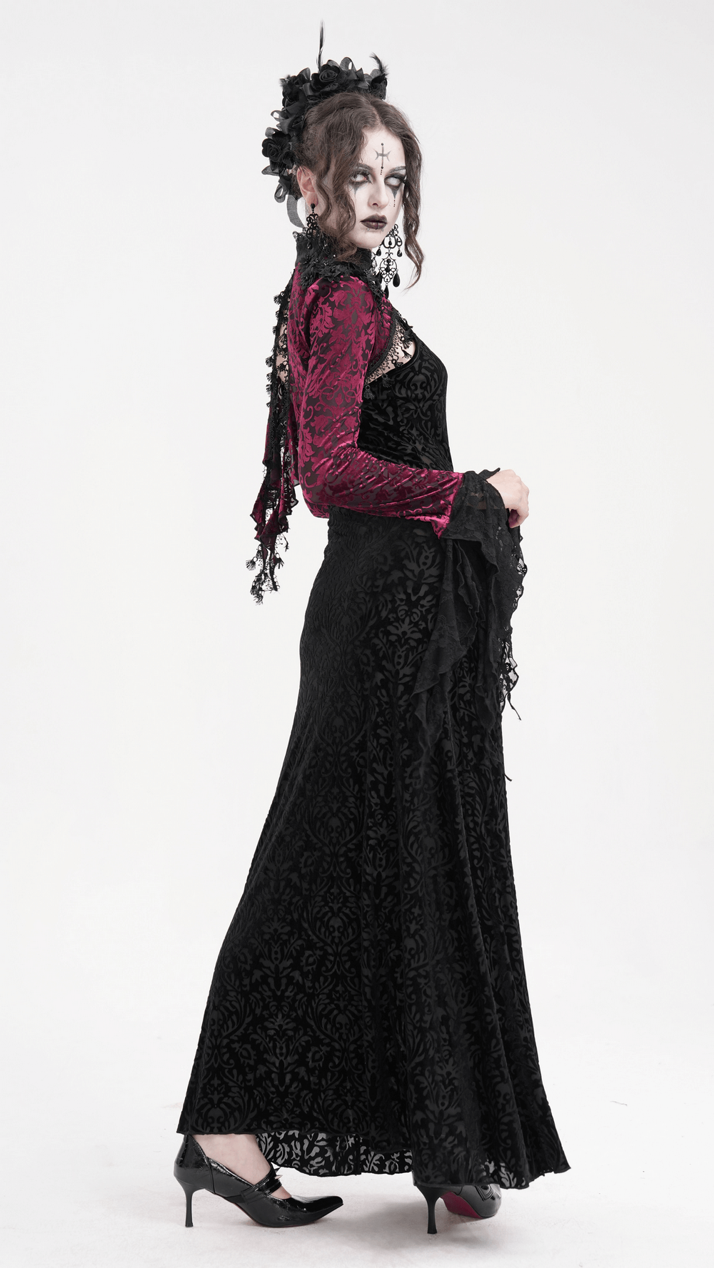 Model showcasing a gothic burgundy lace bolero with dramatic bell sleeves, paired with a stunning black gown.