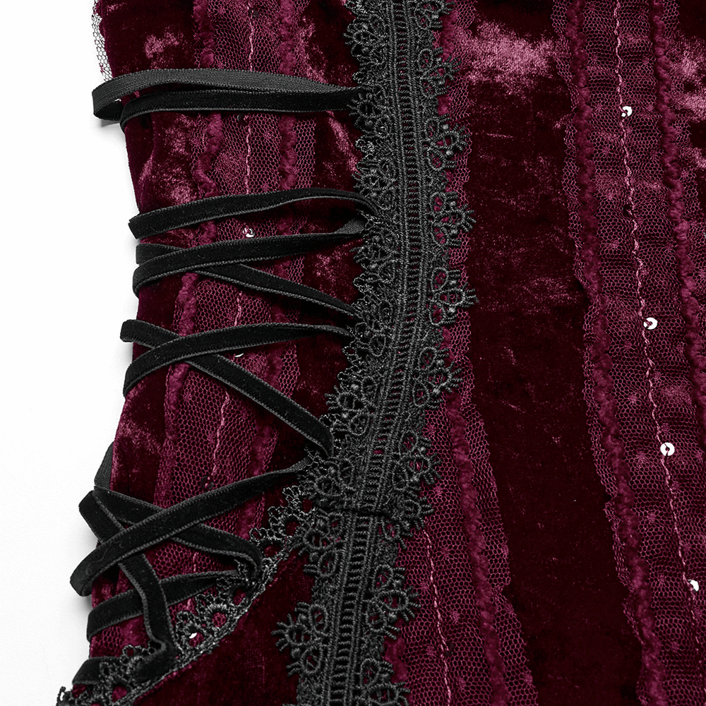 Close-up of gothic burgundy velvet dress details with lace trim and adjustable side straps.