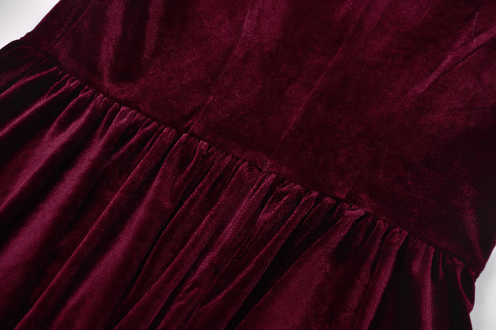 Close-up of the pleated burgundy velvet skirt of a gothic mini dress with elegant texture and rich color.